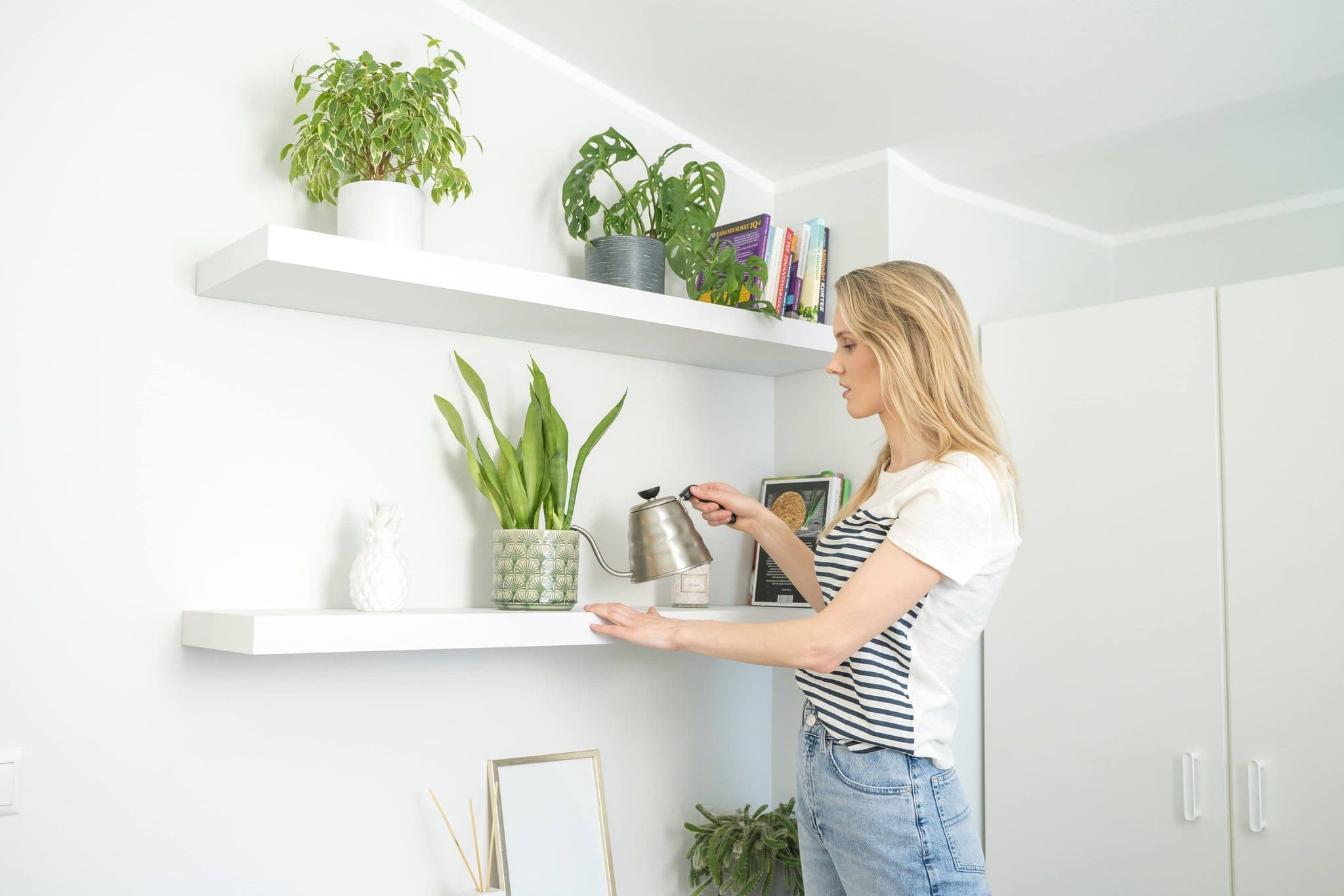 Noor naine kastab korteris taimi