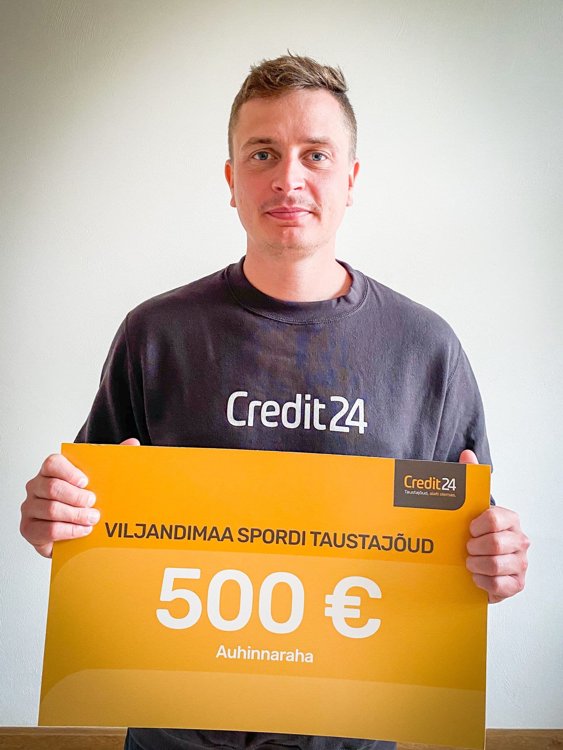 Mees hoiab käes 500-eurost Credit24 vautšerit