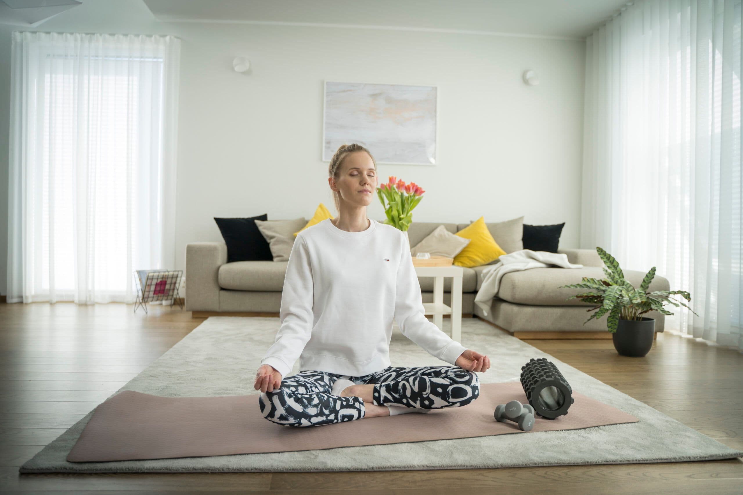 Noor naine mediteerib elutoas põrandal istudes