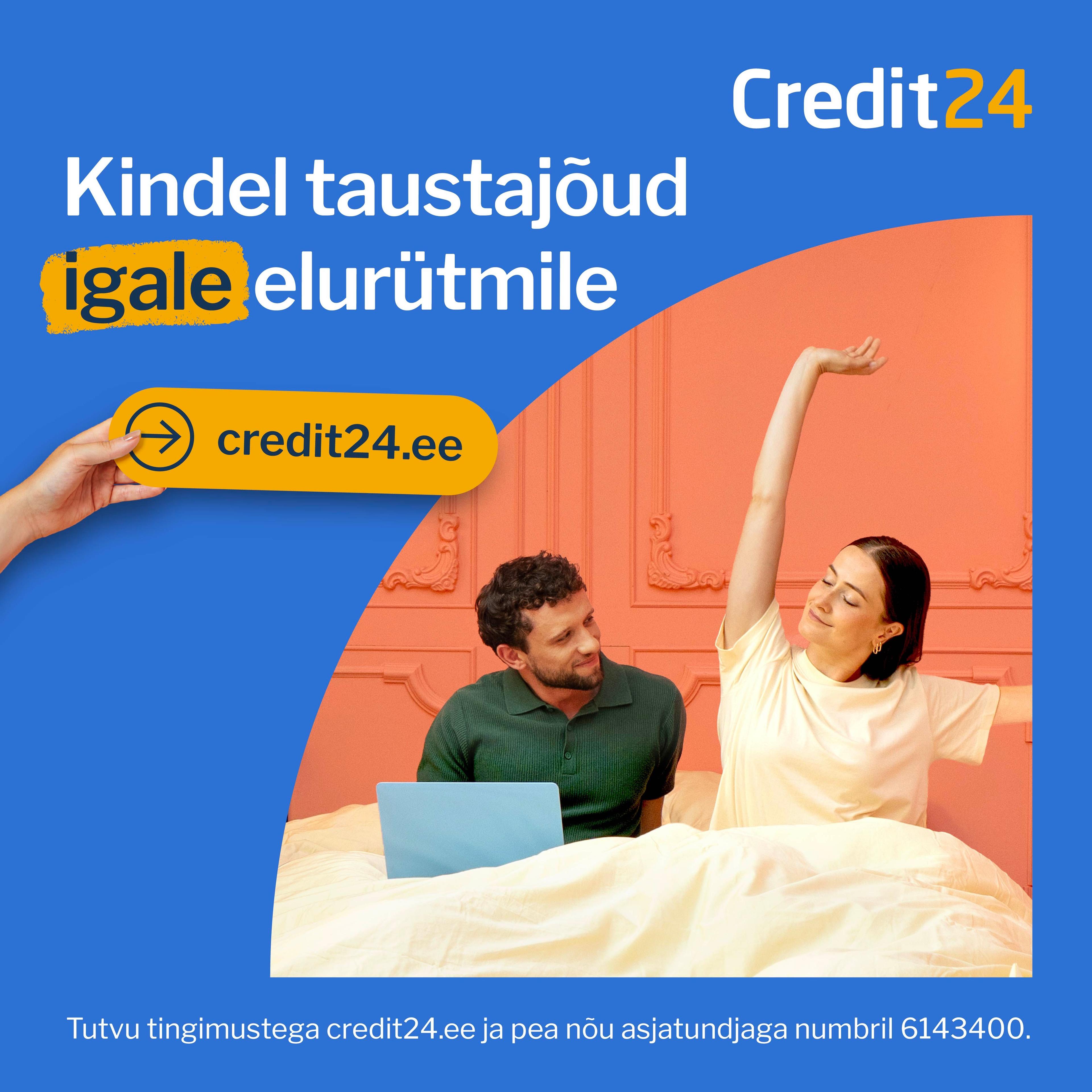 Inimene udustatud näoga hoiab nutitelefoni, istudes laua taga, millel on kollaste lillede vaas; taustal on köögikapid