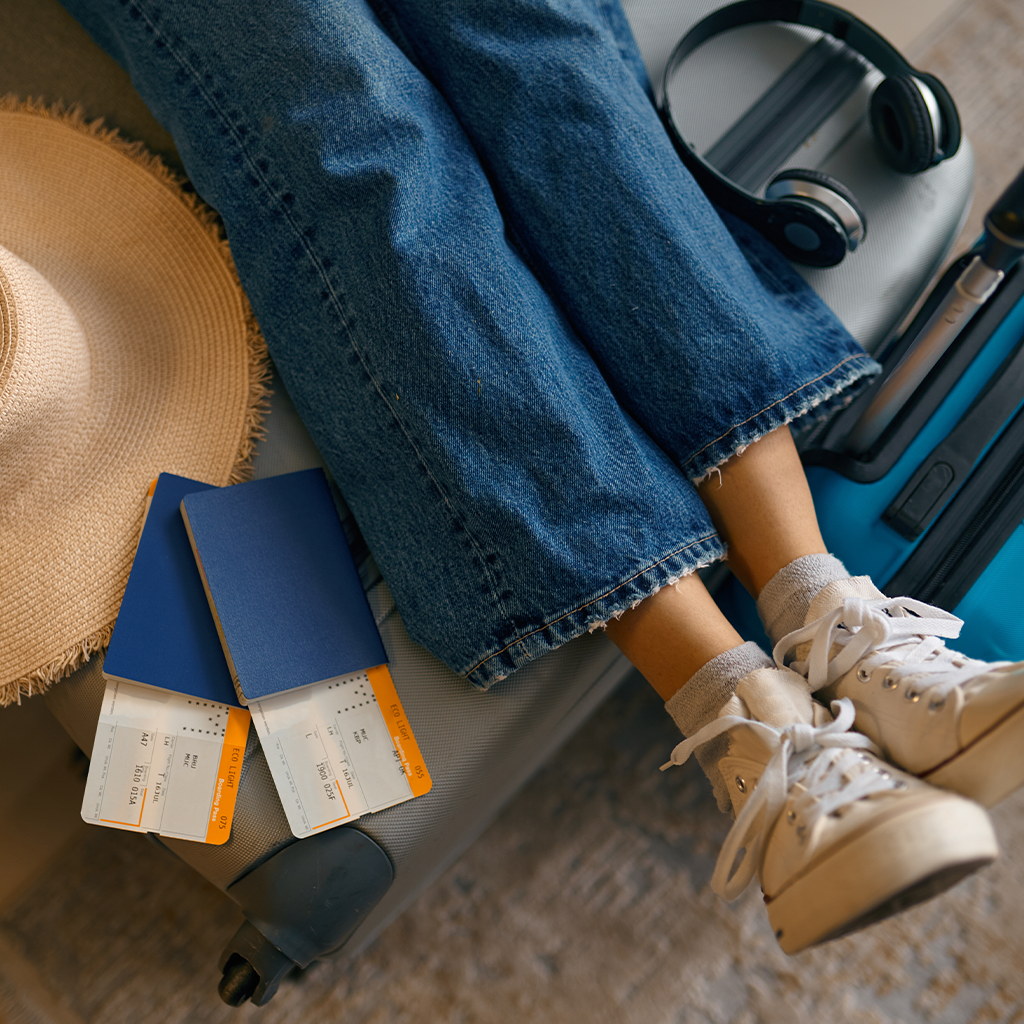 Inimene udustatud näoga hoiab nutitelefoni, istudes laua taga, millel on kollaste lillede vaas; taustal on köögikapid