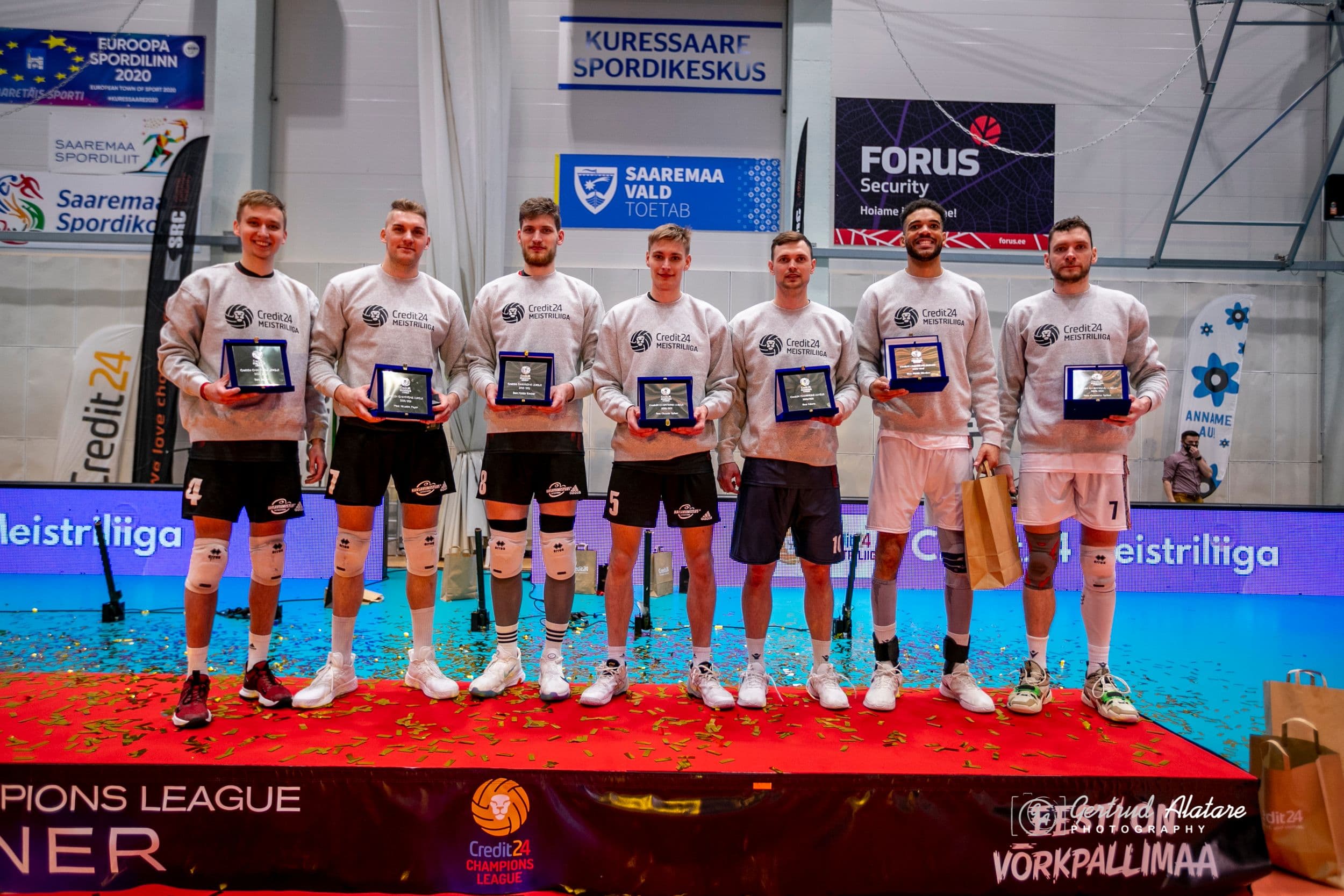 Seitse inimest seisavad laval "Credit24 Meistriliiga" pusades ja hoiavad auhindu, taustal spordikeskuse ja toetajate bännerid.