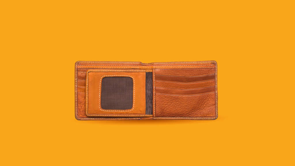 Avatud pruun nahast rahakott oranžil taustal, nähtavad kaardipesad ja ID-aknake