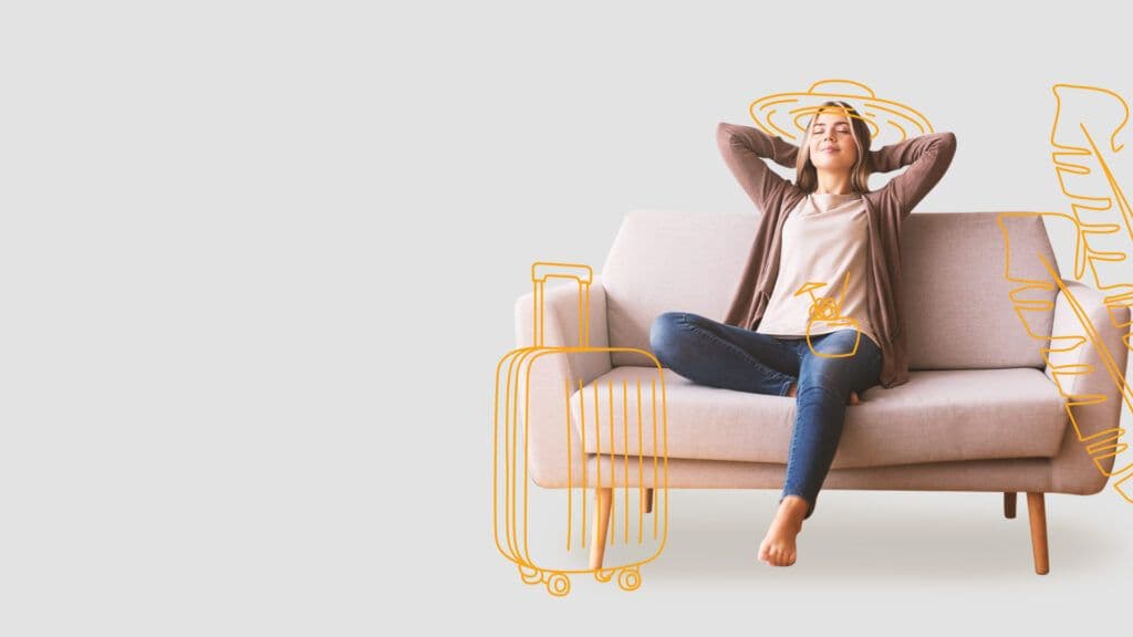 Inimene istub diivanil, taustal oranžid reisiteemalised joonised – kohver, lennuk ja müts